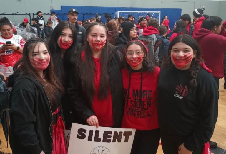 The Missing and Murdered Indigenous Relatives March "Silent" poster held by children.